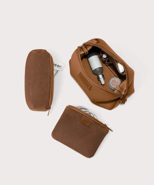 Hunter large toiletry bag in a saturated, warm medium-brown with burnt orange undertones unzipped, top down view.