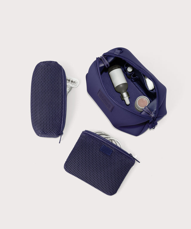 Hunter Large toiletry bag in  a jewel-toned, deep blue with strong purple undertones unzipped, top down view.