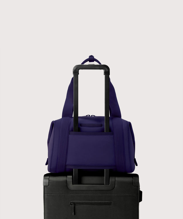 Medium Landon Carryall in a jewel-toned, deep blue with strong purple undertones displaying luggage sleeve
