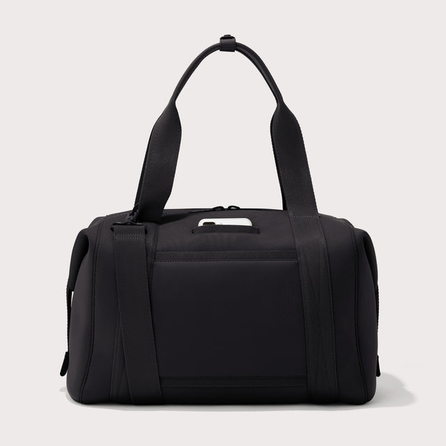 Large Landon Carryall in black, displaying an exterior phone pocket, angle