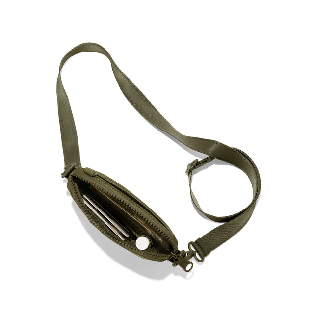 Dagne Dover Mara Phone Sling unzipped in dark green air mesh seen from above, exposing the interior card slots.