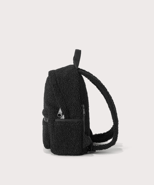 Dakota Small backpack pack in a black, side view  In a  Faux Shearling  a soft, wool-like plush made with recycled materials