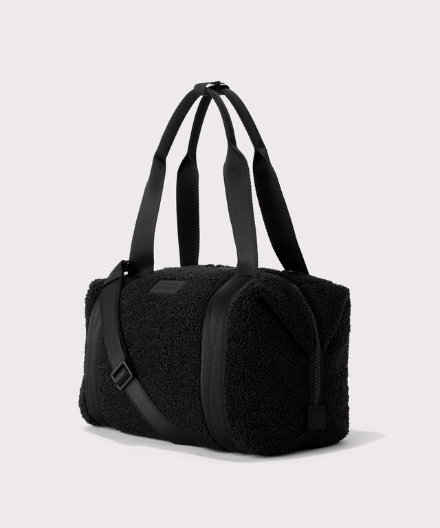 Medium landon carryall in a black. side angle view  In a  Faux Shearling  a soft, wool-like plush made with recycled materials