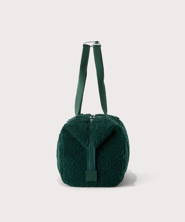 small landon carryall in a saturated, jewel-toned deep green with bold blue undertones., side view  In a  Faux Shearling  a soft, wool-like plush made with recycled materials