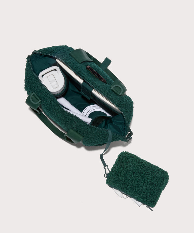 small landon carryall in a saturated, jewel-toned deep green with bold blue undertones. . unzipped, top down view.  In a  Faux Shearling  a soft, wool-like plush made with recycled materials