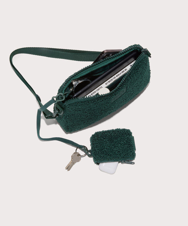 nora shoulder bag in a saturated, jewel-toned deep green with bold blue undertones . unzipped, top down view.  In a  Faux Shearling  a soft, wool-like plush made with recycled materials