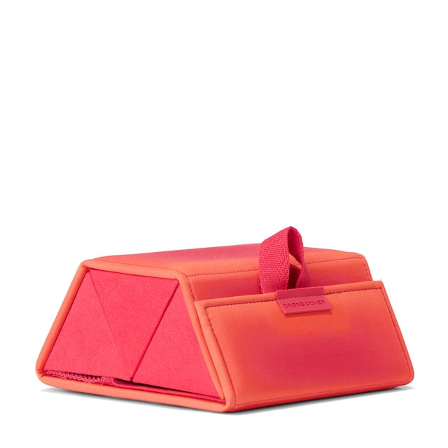 Dagne Dover Remi foldable glasses holder in dark a sun-bleached novelty treatment with fruit punch and pops of airbrushed orange seen from an angle.