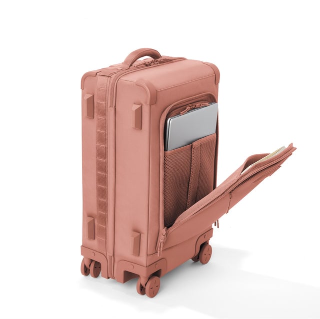 ¾ front view of Seattle carry-on rolling luggage 23.5” in warm dust with front flap opened. Caption: Interior slip pocket fits most 16