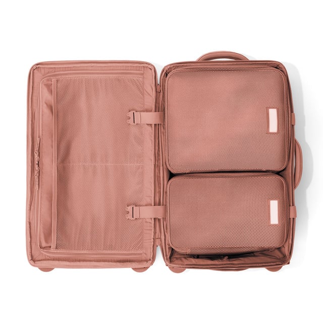 Top down of Seattle carry-on rolling luggage 23.5” in warm dust with interior divider zipped and packing cubes packed into the right side. Hover