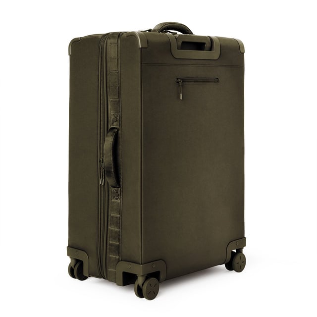 3/4 back view of Sydney checked rolling luggage 28.5” in dark moss showing side handle and back zippered phone/passport pocket