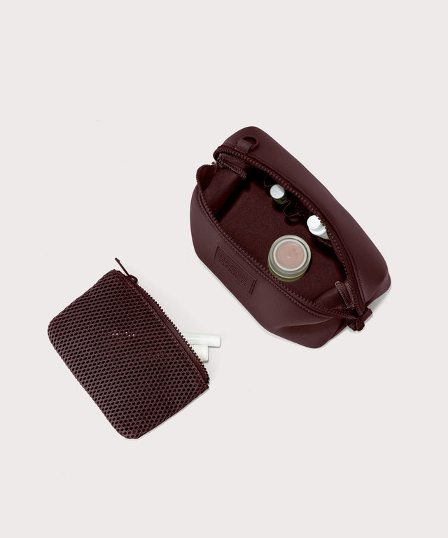 Dagne Dover Small Hunter Toiletry Bag in a deep brown with purple undertones unzipped and seen from above with the removable air mesh pouch alongside it.