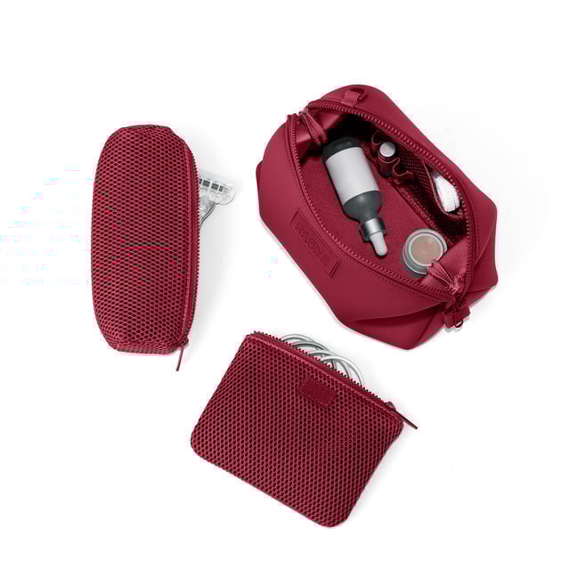 Dagne Dover Large Hunter Toiletry Bag in spice red unzipped and seen from above with the removable air mesh pouch alongside it. hover