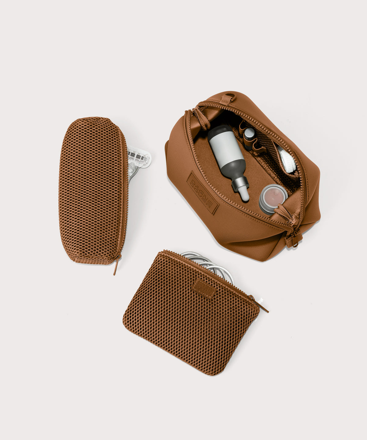 Hunter large toiletry bag in a saturated, warm medium-brown with burnt orange undertones unzipped, top down view. 
