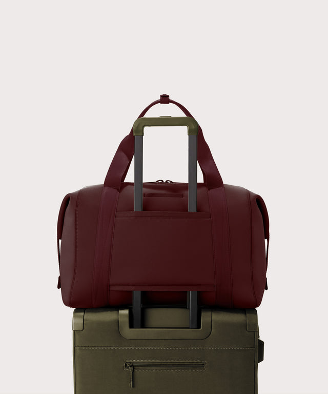Dagne Dover Extra Large Landon Carryall in a deep brown with purple undertones  displaying luggage sleeve.