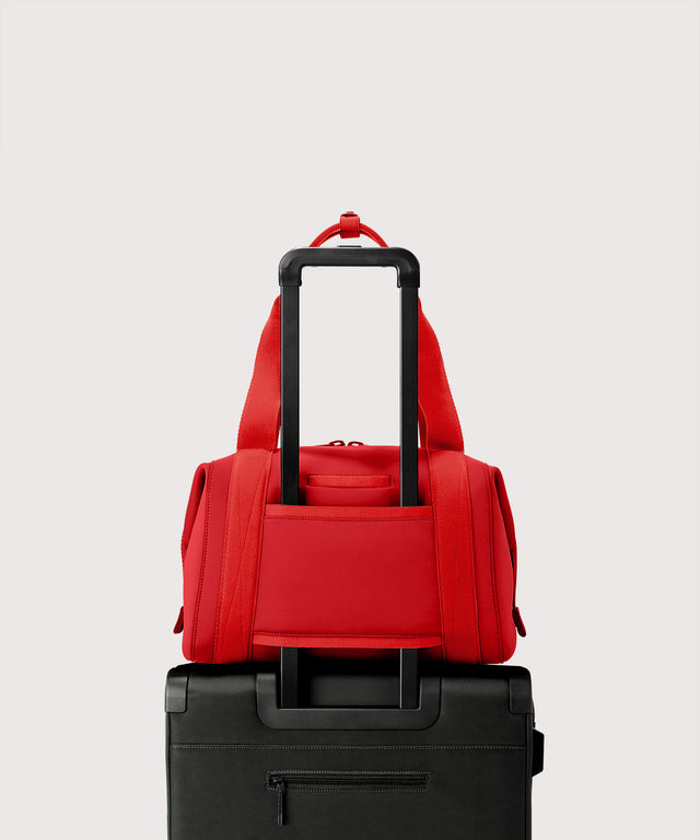 Dagne Dover Medium Landon Carryall in a fiery, saturated red leaning toward orange  displaying luggage sleeve.