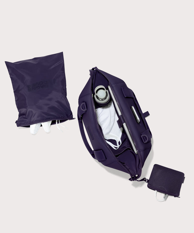 Medium Landon Carryall in a jewel-toned, deep blue with strong purple undertones unzipped, top down view. 
