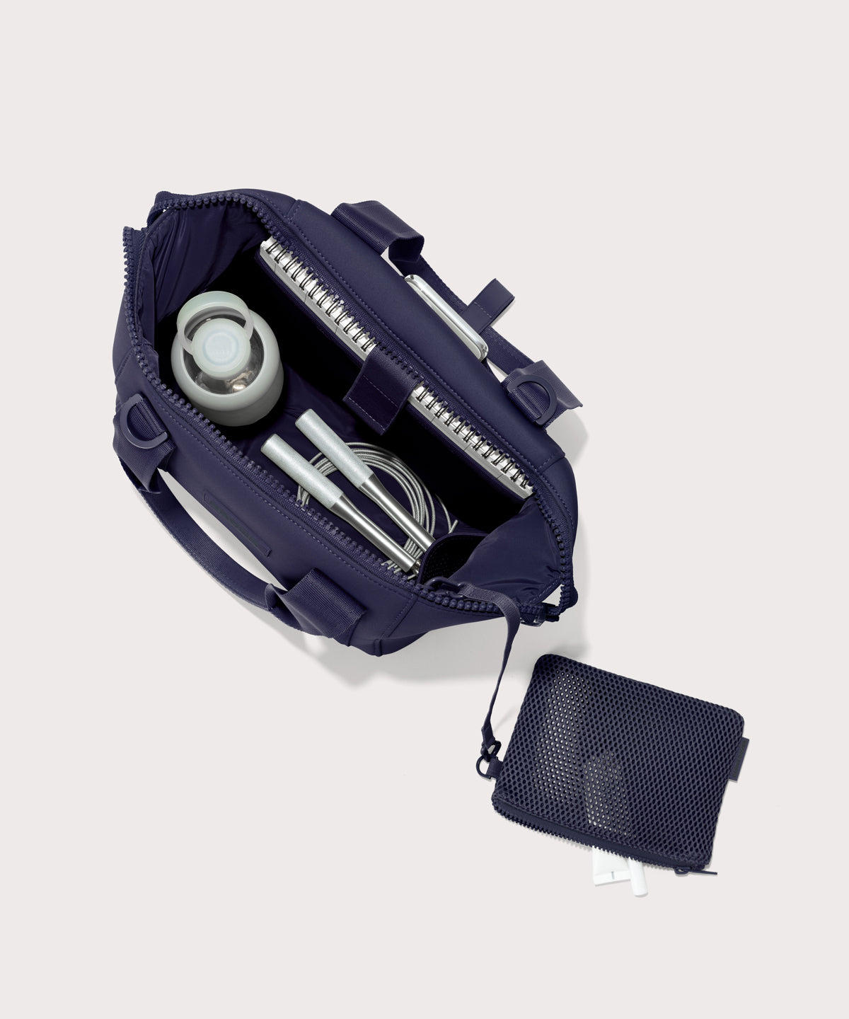 Small Landon Carryall in a jewel-toned, deep blue with strong purple undertones unzipped, top down view. 
