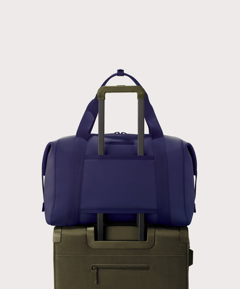  Extra Large Landon Carryall in a jewel-toned, deep blue with strong purple undertones displaying luggage sleeve
