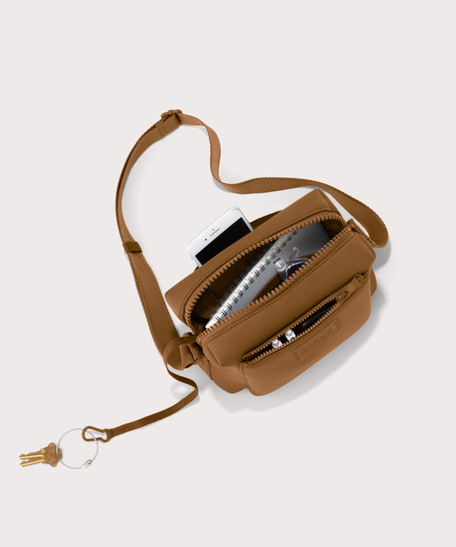 Micah crossbody bag in a saturated, warm medium-brown with burnt orange undertones unzipped, top down view. 
