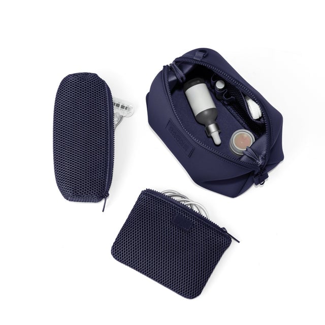 Dagne Dover Large Hunter Toiletry Bag in navy blue unzipped and seen from above with the removable air mesh pouch alongside it.