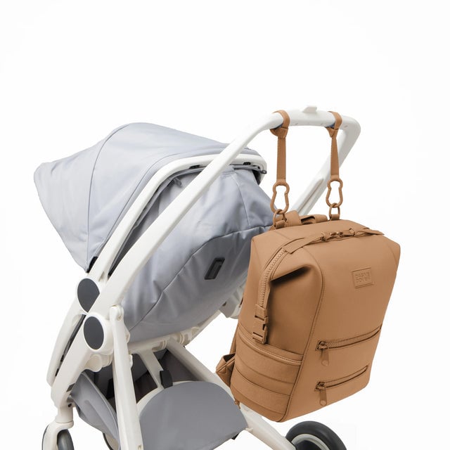 Dagne Dover Large Indi Diaper Backpack in camel brown attached to a stroller.