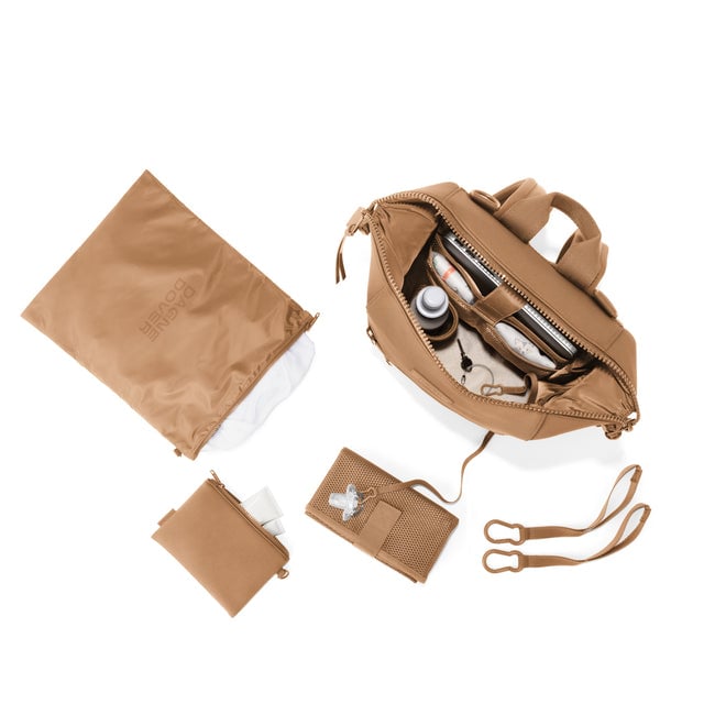 Dagne Dover Medium Indi Diaper Backpack in camel brown showing it's water resistant bag, interior pockets, and changing mat.
