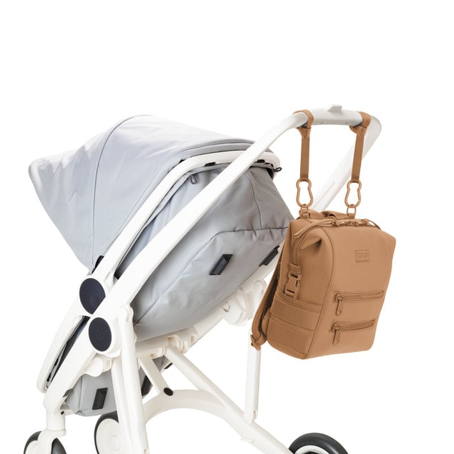 Dagne Dover Small Indi Diaper Backpack in camel brown attached to a stroller.