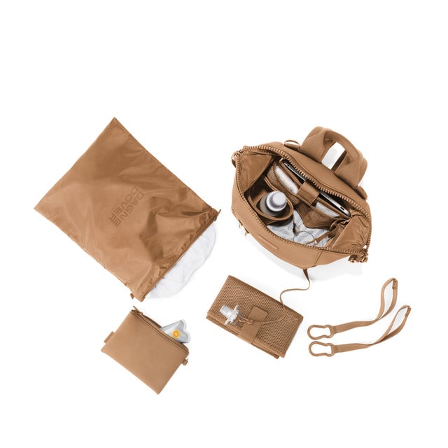 Dagne Dover Small Indi Diaper Backpack in camel brown showing it's water resistant bag, interior pockets, and changing mat.