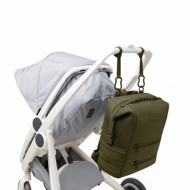 Dagne Dover Large Indi Diaper Backpack in dark green attached to a stroller.