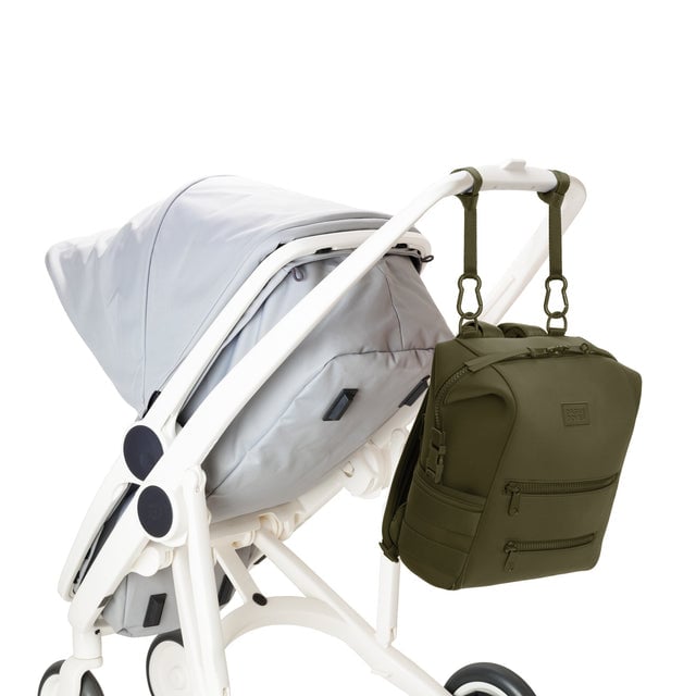 Dagne Dover Medium Indi Diaper Backpack in dark green attached to a stroller.