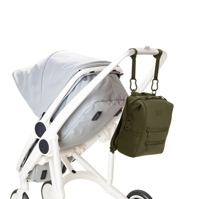 Dagne Dover Small Indi Diaper Backpack in dark green attached to a stroller.