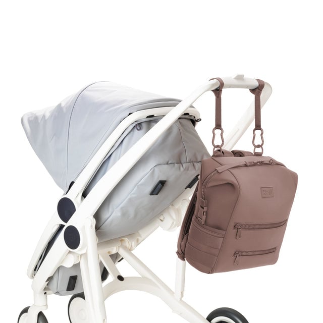 Dagne Dover Medium Indi Diaper Backpack in dune pink attached to a stroller.