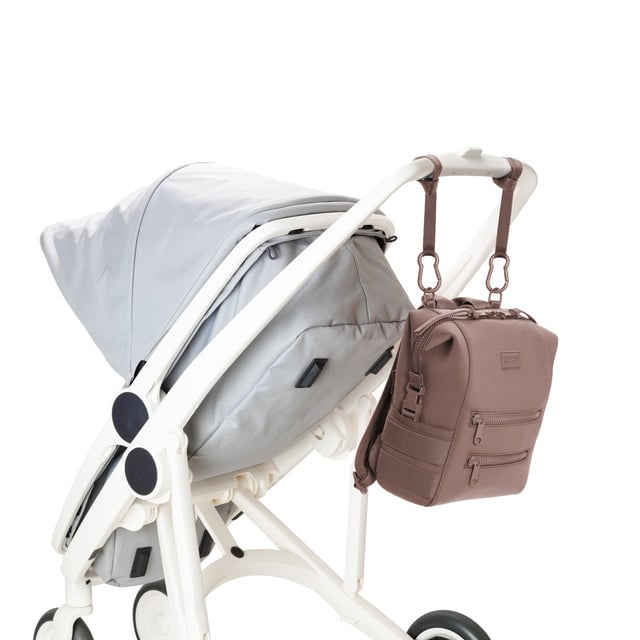 Dagne Dover Small Indi Diaper Backpack in dune pink attached to a stroller.