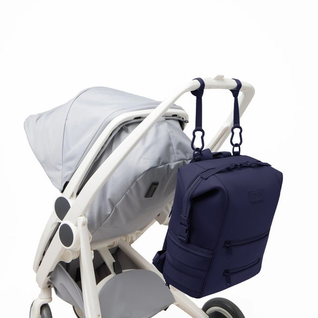 Dagne Dover Large Indi Diaper Backpack in dark blue attached to a stroller.