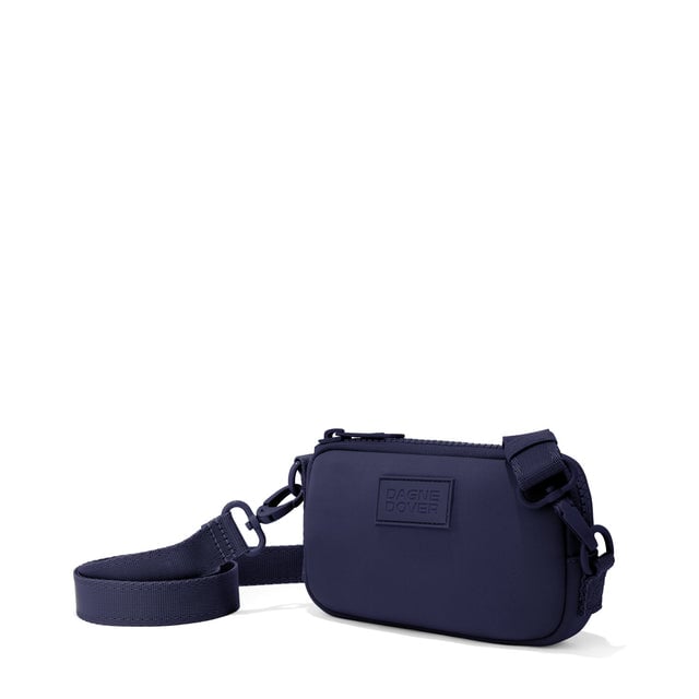 Dagne Dover Mara Phone Sling in navy blue seen from an angle, showing the adjustable shoulder strap drop.