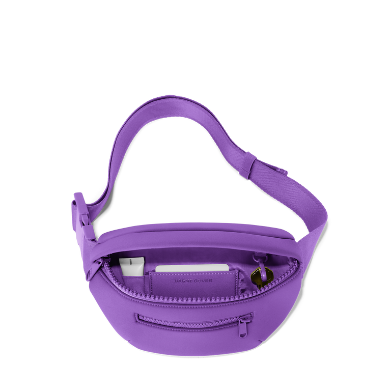 Dagne Dover Ace Fanny Pack in a bright saturated purple unzipped, exposing the interior pockets. hover