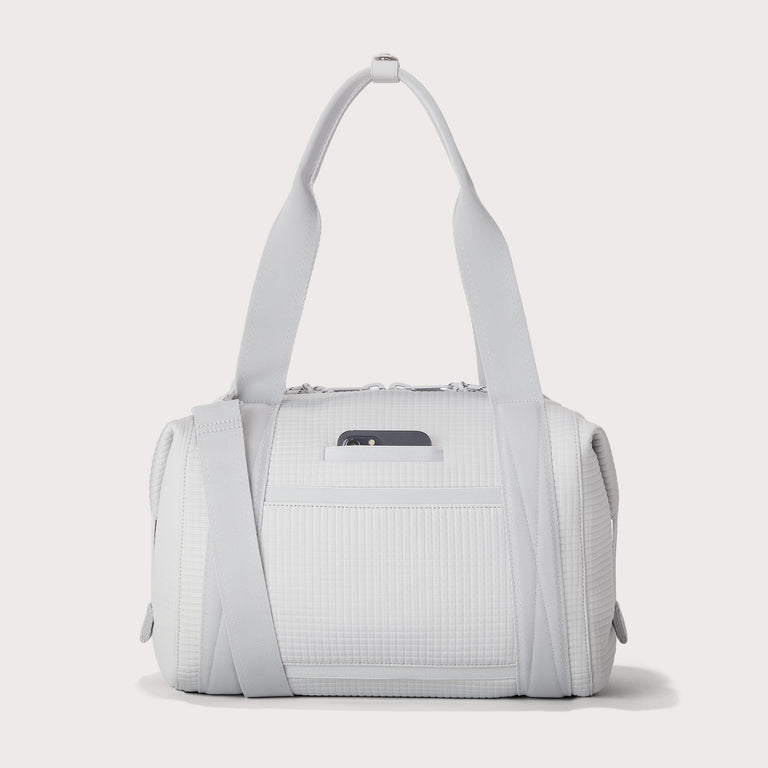 Dagne Dover Medium Landon Carryall in a muted light grey with classic waffle texture, displaying an exterior phone pocket. EDEAE8 .