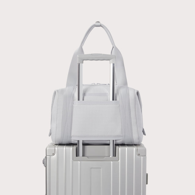 Dagne Dover Medium Landon Carryall in a muted light grey with classic waffle texture displaying luggage sleeve. EDEAE8.