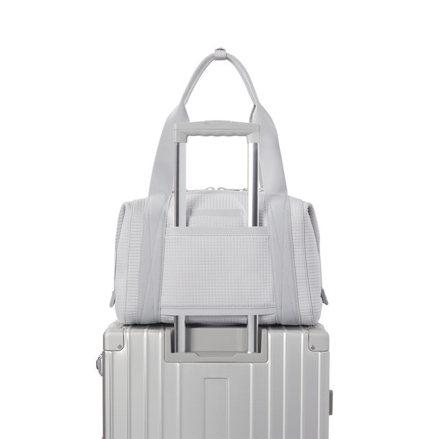 Dagne Dover Medium Landon Carryall in a muted light grey with classic waffle texture displaying luggage sleeve.