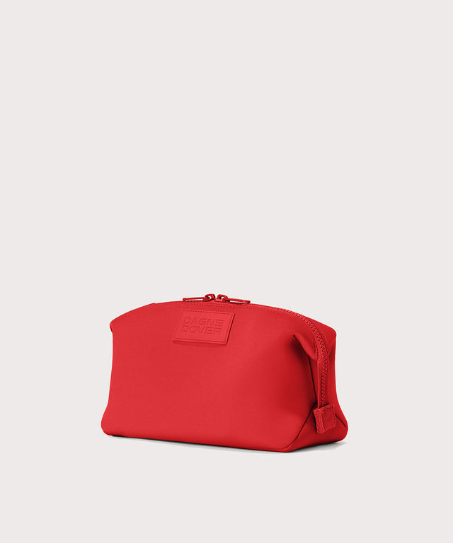 Dagne Dover Large Hunter Toiletry Bag in a fiery, saturated red leaning toward orange seen from an angle.
