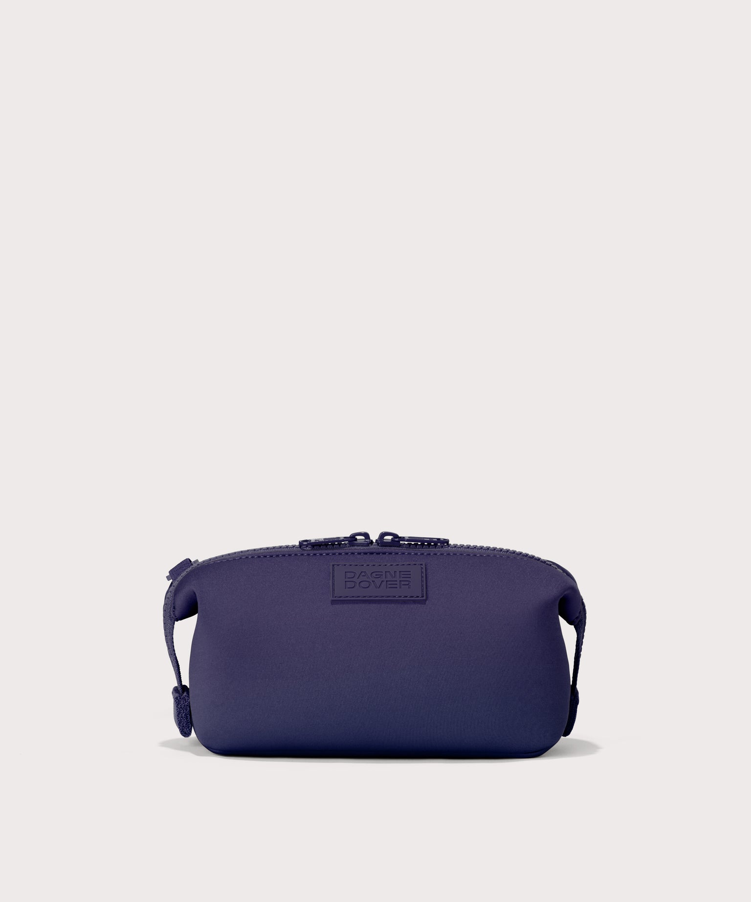 Hunter small toiletry bag in a jewel-toned, deep blue with strong purple undertones.. Front view. 
