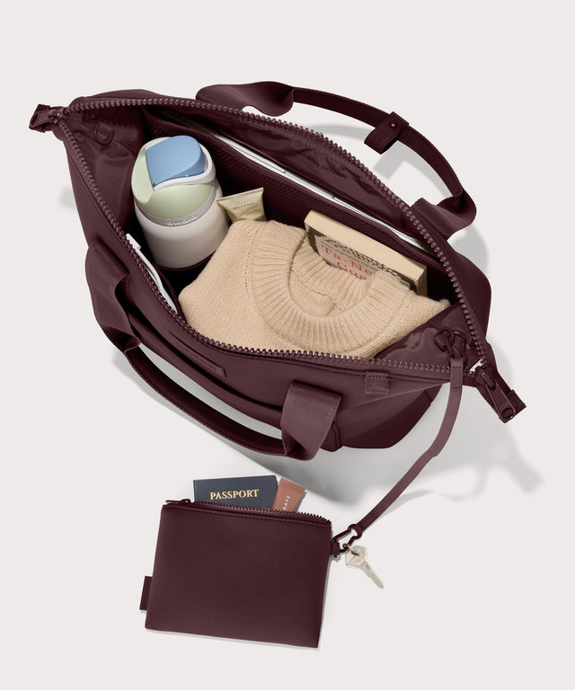 Tote  bag in a deep brown with purple undertones reminiscent of maroon seen from the top down view showing interior mesh pouch.
