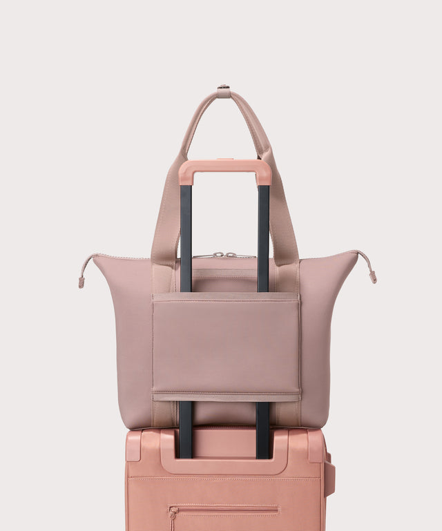 Tote  bag in a  pink seen from the back view on suitcase.
