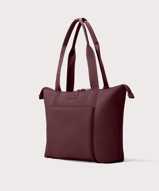 Tote  bag in a deep brown with purple undertones reminiscent of maroon seen from the angle view .