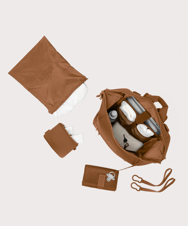 Large Indi backpack in a saturated, warm medium-brown with burnt orange undertones. unzipped, top down view. 

