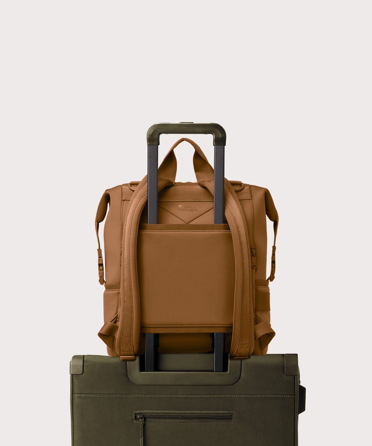 Large Indi backpack in a saturated, warm medium-brown with burnt orange undertones. displaying luggage sleeve
