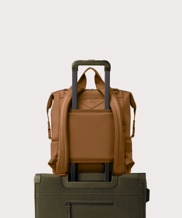 Large Indi backpack in a saturated, warm medium-brown with burnt orange undertones. displaying luggage sleeve
