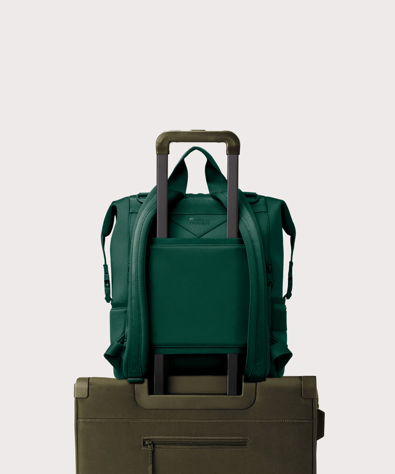 Large Indi backpack in a saturated, jewel-toned deep green with bold blue undertones. displaying luggage sleeve
