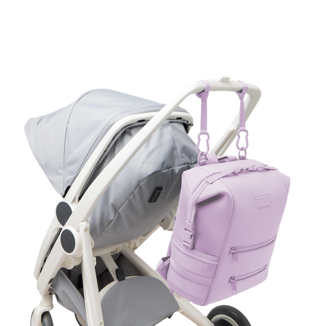 Dagne Dover Large Indi Diaper Backpack in a soft purple with grey undertones attached to a stroller.
