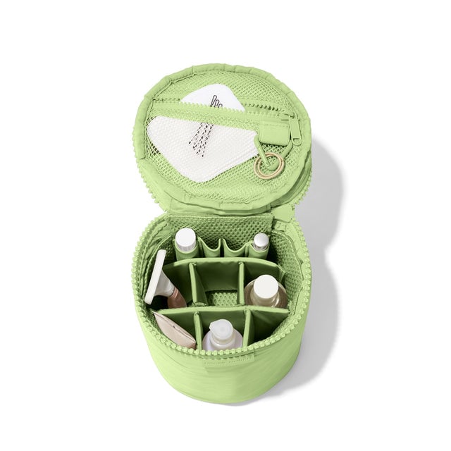 hover Dagne Dover large Mila Toiletry Pouch in matcha green unzipped filled with toiletry products.